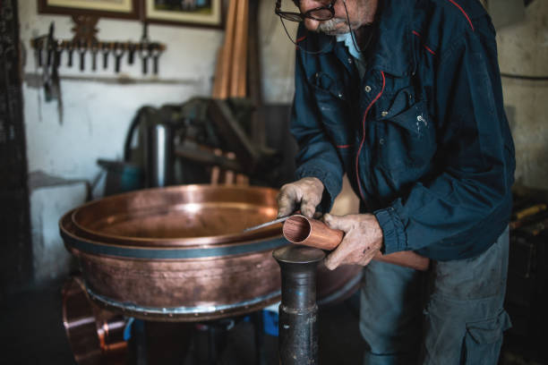 istock An old man,a worker in a workshop for making cauldrons for an alcohol distillation. 1343879687