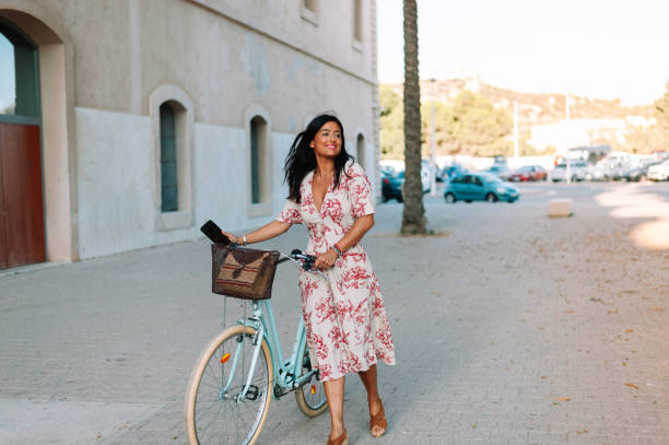 istock Charming young woman is smiling while riding a bicycle stock photo 1343879897