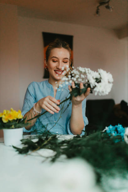 istock Smiling young woman making flower bouquets at home 1343884505