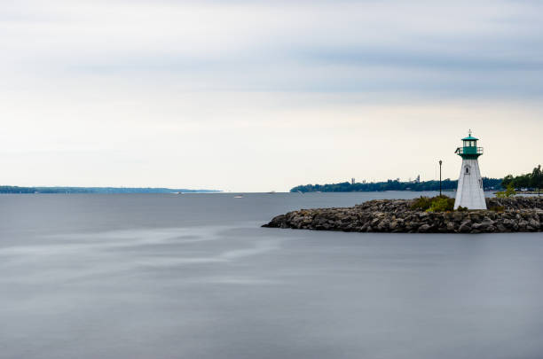 istock a small lighthouse with storm clouds in the background with smooth water 1343885214