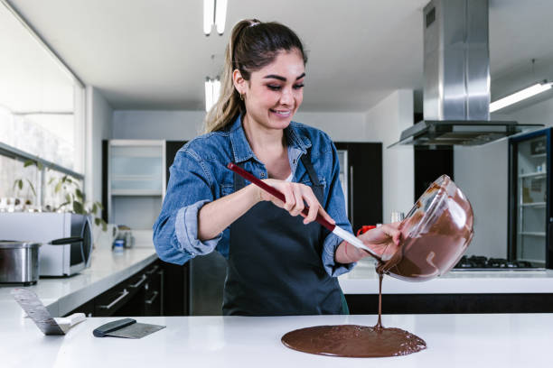 joven hispana pastelera en proceso de preparación de chocolate mexicano en cocina en méxico latinoamérica - cake women confectioner photography fotografías e imágenes de stock