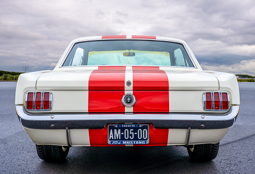 ROTTERDAM / NETHERLANDS - AUGUST 18 2019: Back view of a red striped and white classic Ford Mustang 1965 on display at a classic car meeting