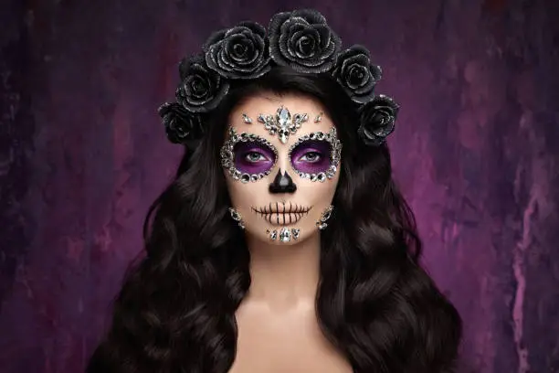 Portrait of a woman with sugar skull makeup over red background. Halloween costume and make-up. Portrait of Calavera Catrina