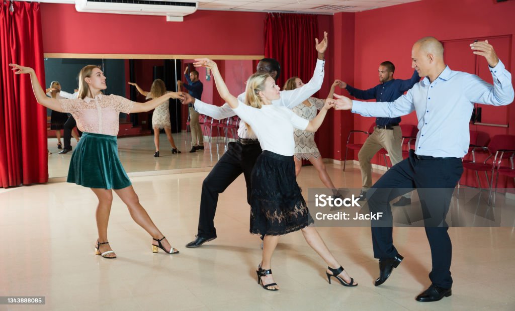 Couples enjoying boogie-woogie Adult dancing couples enjoying active boogie-woogie in modern studio Swing Dancing Stock Photo