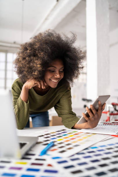 istock Smiling afro female designer in a creative office, working on laptop 1343889374
