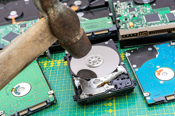 istock Destruction, deleting of data, information on a hard disk drive with hammer 1343889483