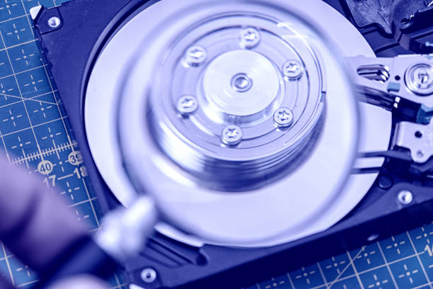 istock hard disk drive through a magnifying glass, information search, diagnostics, restore 1343889495
