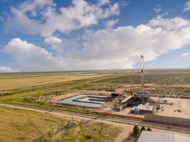 istock Fracking Drilling Rig Evening Shot under dramatic Sky in West Texas with Settling Ponds on the Prairie 1343890073