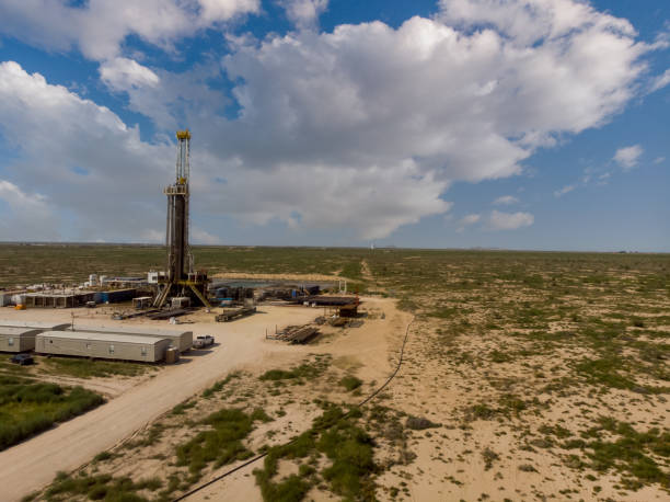 istock Fracking Drilling Rig Evening Shot under dramatic Sky in West Texas with Settling Ponds on the Prairie 1343890074