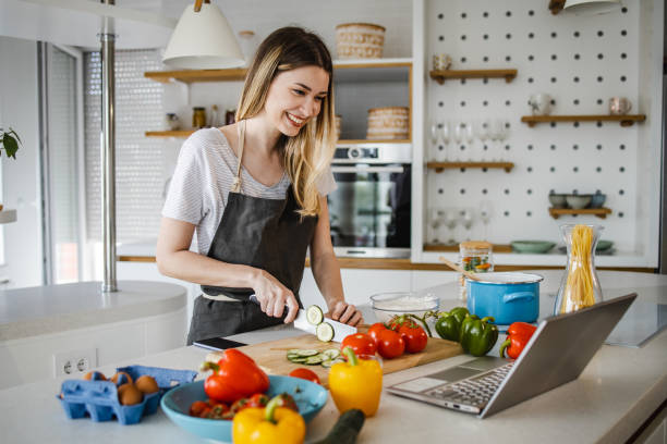 istock Young woman preparing dinner at home 1343893745