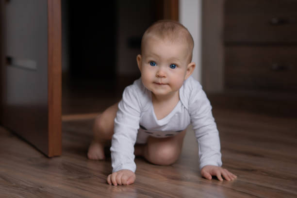 Adorable baby crowling on the floor and having a good time. Image with selective focus