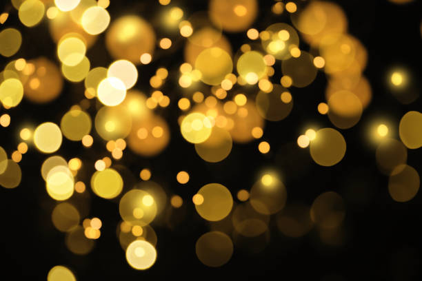 istock Blurred view of gold lights on black background, bokeh effect 1343896840