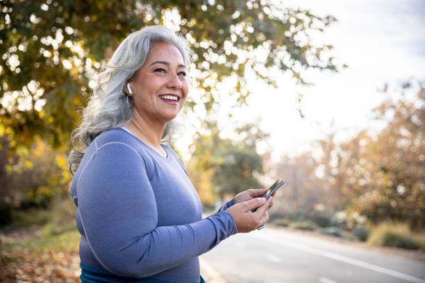 belle femme avec smartphone se préparant pour l��’entraînement - medical cross photos et images de collection