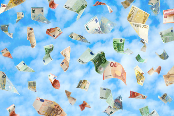 istock Falling Euro banknotes and blue sky on background. Money rain 1343897107