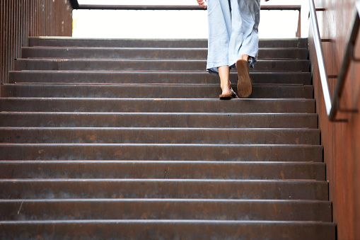 A woman in summer clothes goes up a staircase, Austria, Europe