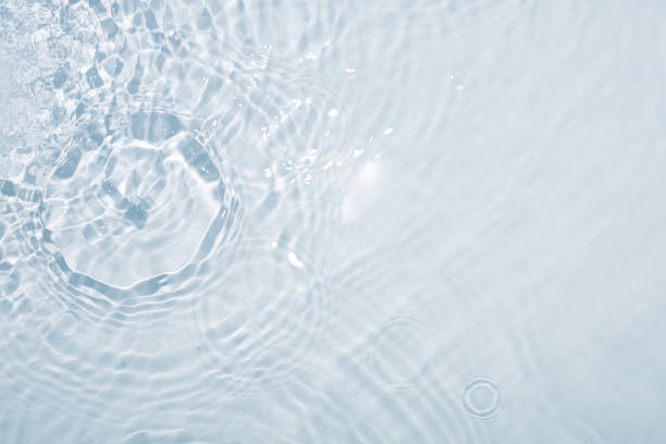 light blue water background with circles from drops - golf water stockfoto's en -beelden