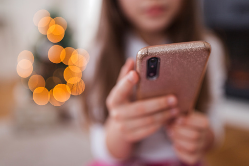 Child holding smart phone, close-up on a phone