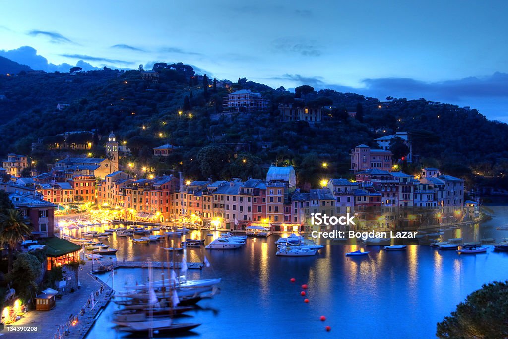 Portofino sunset, Italy Portofino is the most exclusive harbour and resort town in Italy. It is located on Ligurian coast near Genoa, at the tip of a peninsula bearing the same name, Portofino. Twilight view from the hill of San Giorgio church using HDR technique. Portofino Stock Photo