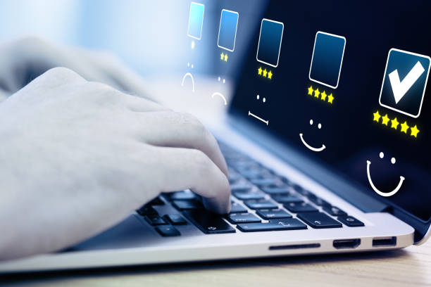 istock Close up of hands using laptop and choosing 5 stars on abstract glowing rating interface on blurry background. Customer service, ranking and feedback concept. 1343910901