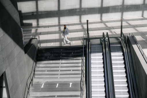 High angle view of a businessman on steps in commercial building. Executive moving down from steps in a city buidling.