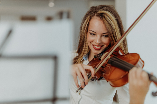 Young woman practicing on her violin