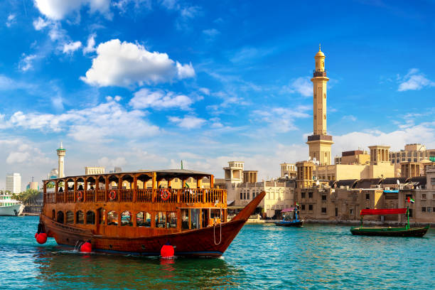Dhow wooden ship in Dubai Dhow - old traditional wooden ship and Grand Bur Dubai Masjid Mosque  on the bay Creek in Dubai, United Arab Emirates dhow photos stock pictures, royalty-free photos & images