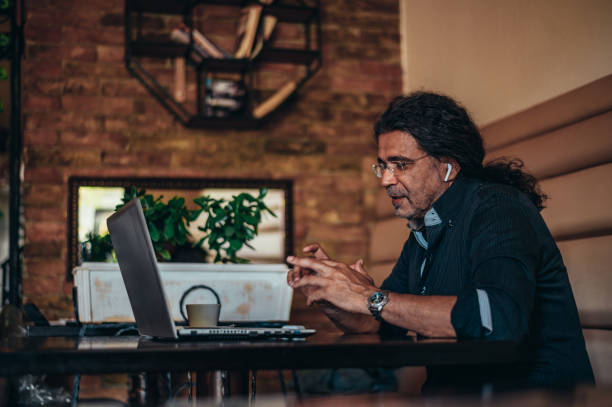istock Senior hispanic cuban men using laptop for an video call in a cafe 1343926135