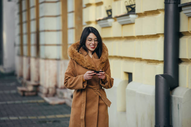 istock Young hispanic woman using smartphone while out in the city 1343926171