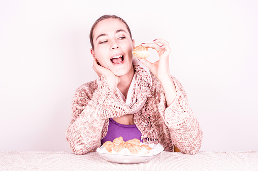 Smiling Woman with Happy Eyes and Joyful Expression Eating Homemade French Cream Puffs