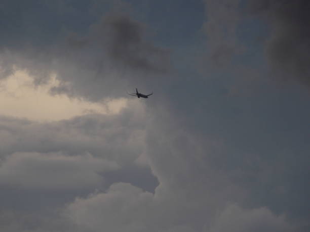 istock Airplane flying towards storm clouds 1343934696