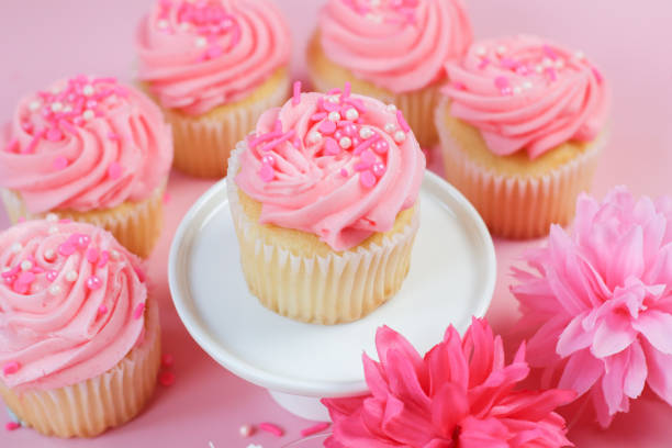 Vanilla cupcakes with pink buttercream frosting and candy sprinkles on top