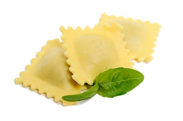 Three pieces of ravioli with two basil leaves