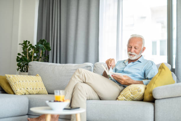 istock Happy senior man reading a book at home. 1343961559