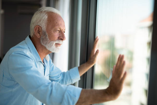 istock Senior man looking through window of his apartment during lockdown. 1343962634