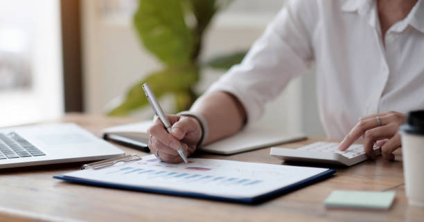 istock asian businesswoman or accountant working pointing graph discussion and analysis data charts and graphs and using a calculator to calculate numbers.Business finances and accounting concept 1343962737
