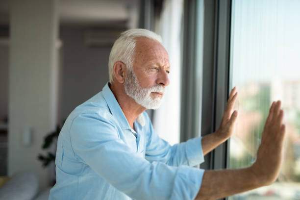 istock Senior man looking through window of his apartment during lockdown. 1343963998