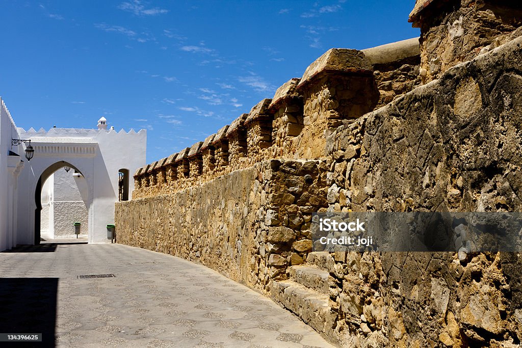 Medina Fortress Wall, Asliah, Morocco Medina Fortress Stone Wall of Asliah that leads to an archway of Islamic architecture Asilah Stock Photo