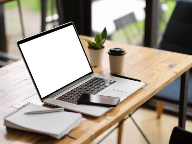 istock Simple workspace with laptop in white screen mockup, mobile phone and supplies on table 1343982576