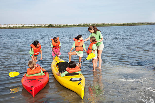 ajudante de colônia de férias de verão e crianças com caiaques - summer camp child teenager kayak - fotografias e filmes do acervo