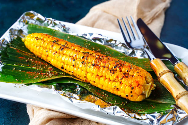 milho grelhado fresco em um prato com pimenta e especiarias. churrasco de milho, refeição vegetal vegana, churrasco - corn corn on the cob grilled roasted - fotografias e filmes do acervo