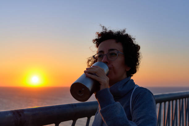 istock A woman drinking water during a sunrise 1343989768