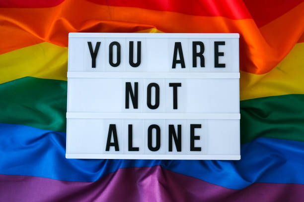 istock Rainbow flag with lightbox and text YOU ARE NOT ALONE. Rainbow lgbtq flag made from silk material. Symbol of LGBTQ pride month. Equal rights. Peace and freedom 1343992470