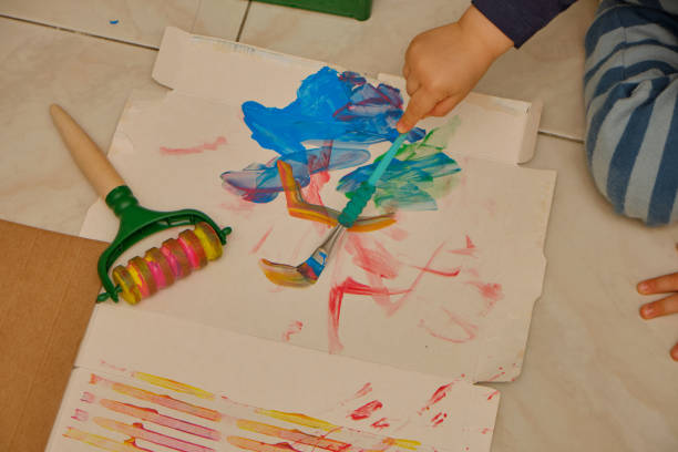 istock Child painting on cardboard with brush. 1343992683