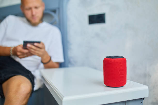 istock Male testing talking smart wireless speaker, man controlling home devices with a voice commands, sitting on sofa at home, Concept of smart home 1343995920