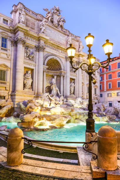 A suggestive evening scene of the majestic Trevi Fountain in the historic and Baroque heart of Rome A splendid evening view of the majestic Trevi Fountain, in the historic and baroque heart of the Eternal City. Built in 1732 on the wishes of Pope Clement XII on the facade of the Palazzo Poli by the architect Nicola Salvi, the Trevi Fountain it's one of the masterpiece of the late Roman Baroque, recognized as one of the most beautiful and famous fountain in the world. In 1980 the historic center of Rome was declared a World Heritage Site by Unesco. Image in high definition format. triton greek god stock pictures, royalty-free photos & images