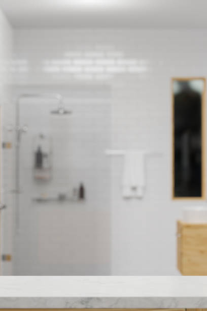 istock Mockup space for montage on white marble tabletop with blurred simple white shower room 1343997320