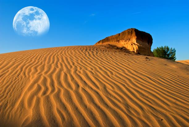 istock huge moon above a sand desert dune 1343997605