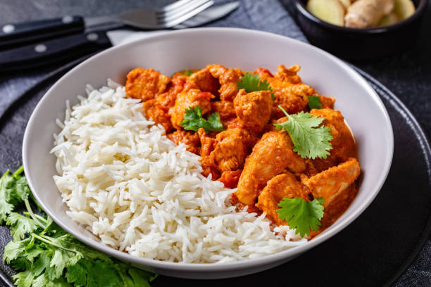 istock butter chicken with long grain rice and coriander, chicken curry in a bowl on a concrete table, english cuisine, horizontal view from above, close-up 1344000353