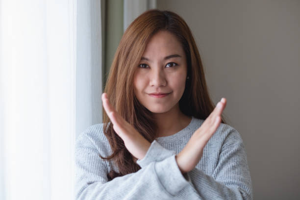 A young woman making crossed arms sign