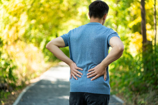 istock Back pain when walking outdoors, man with kidney inflammation on nature background 1344006274
